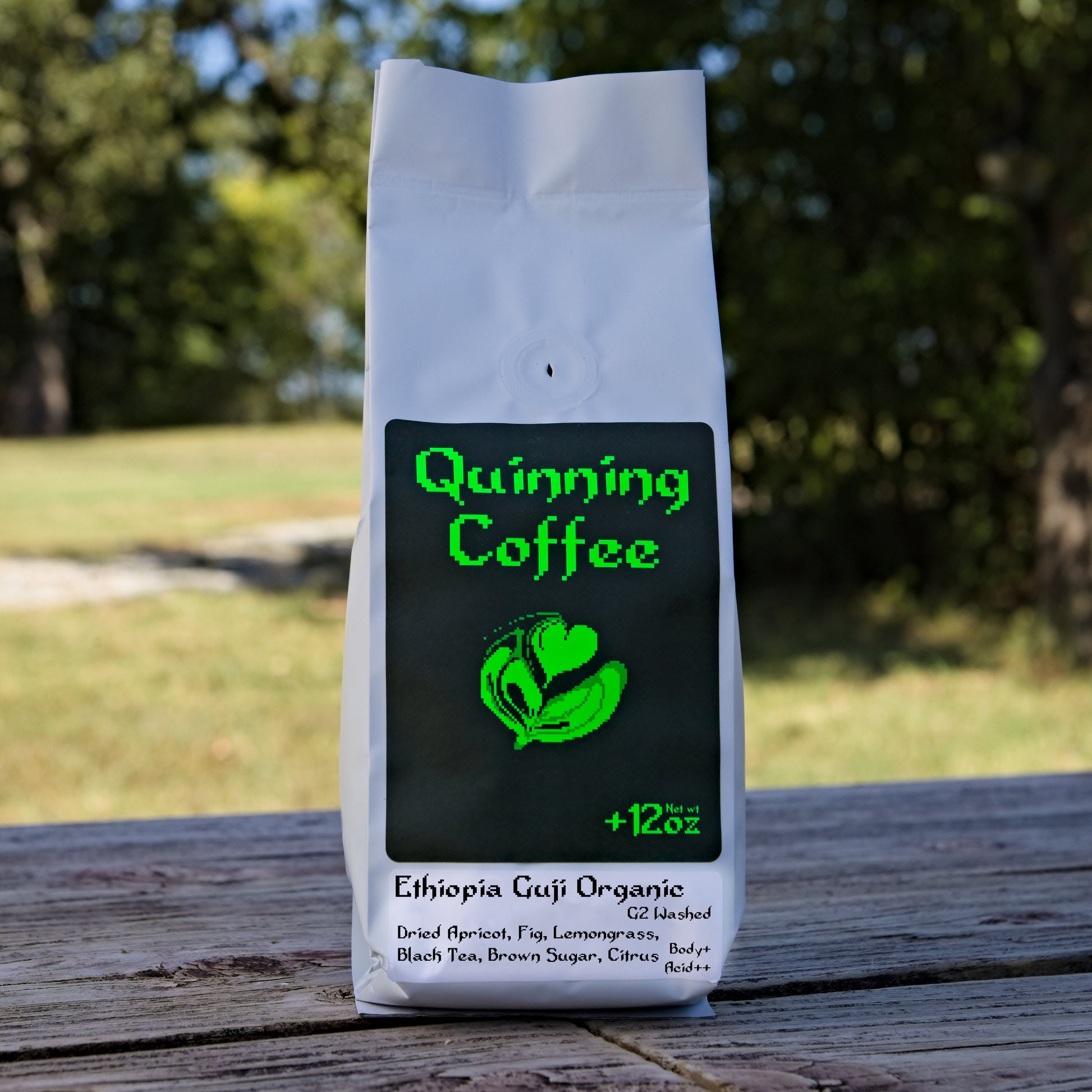 Quinning Coffee Ethiopia Guji Organic G2 Washed dried apricot fig lemongrass black tea brown sugar citrus 12 ounce coffee bag placed on wood with nature background