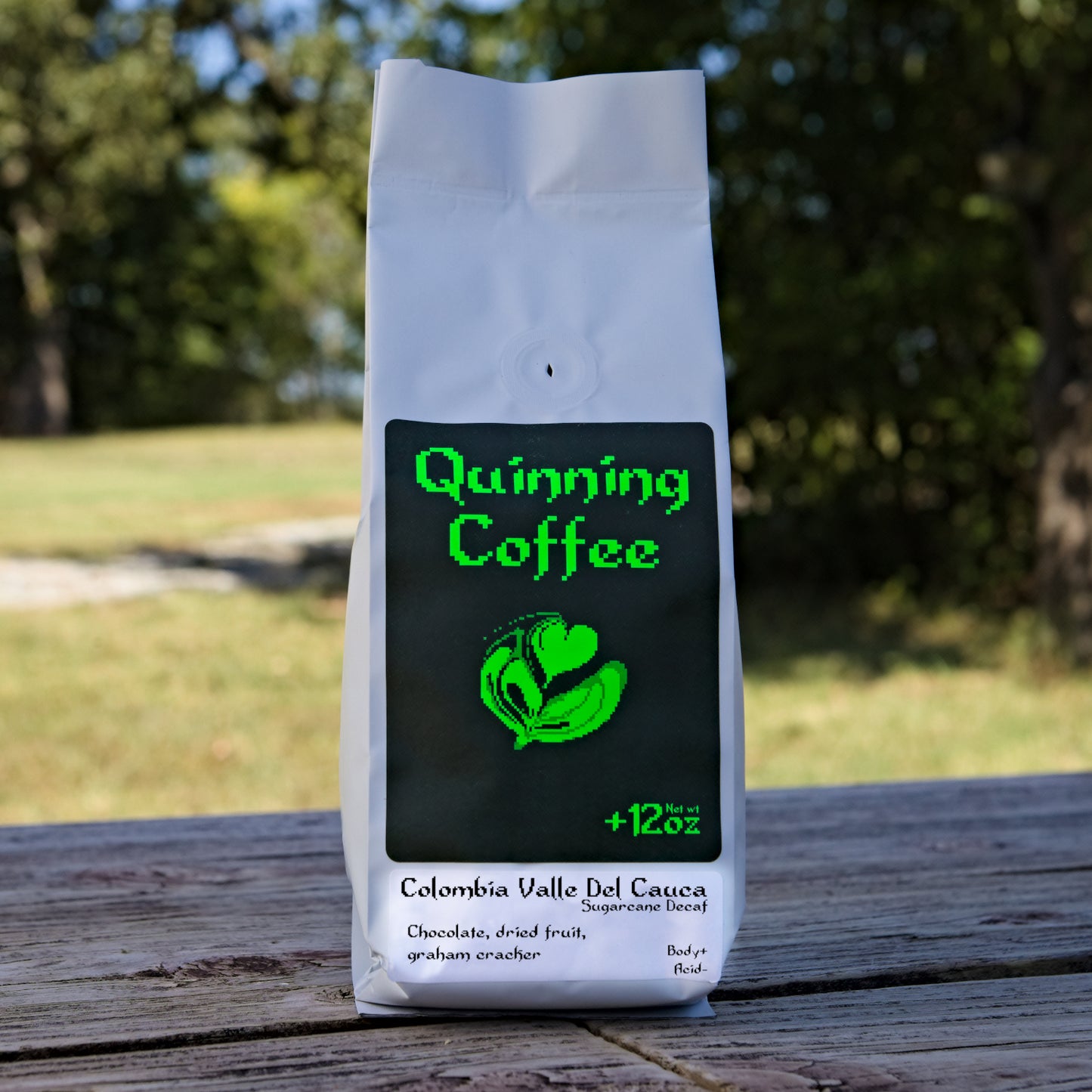 Quinning Coffee Colombia Valle del Cauca Sugarcane Decaf Chocolate dried fruit graham cracker 12 ounce coffee bag placed on wood with nature background